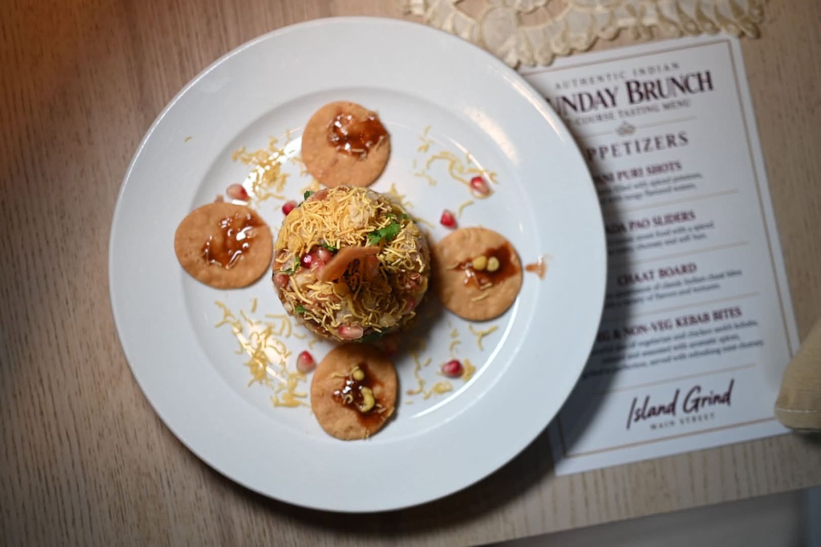 Chaat tower with papdi and pomegranate next to the Sunday brunch tasting menu